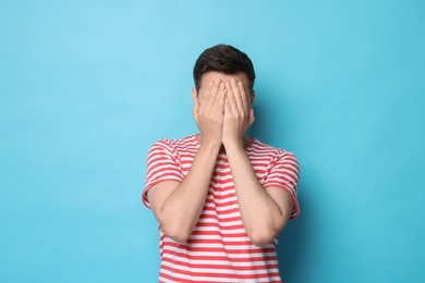 Photo of Portrait of scared young man on light blue background