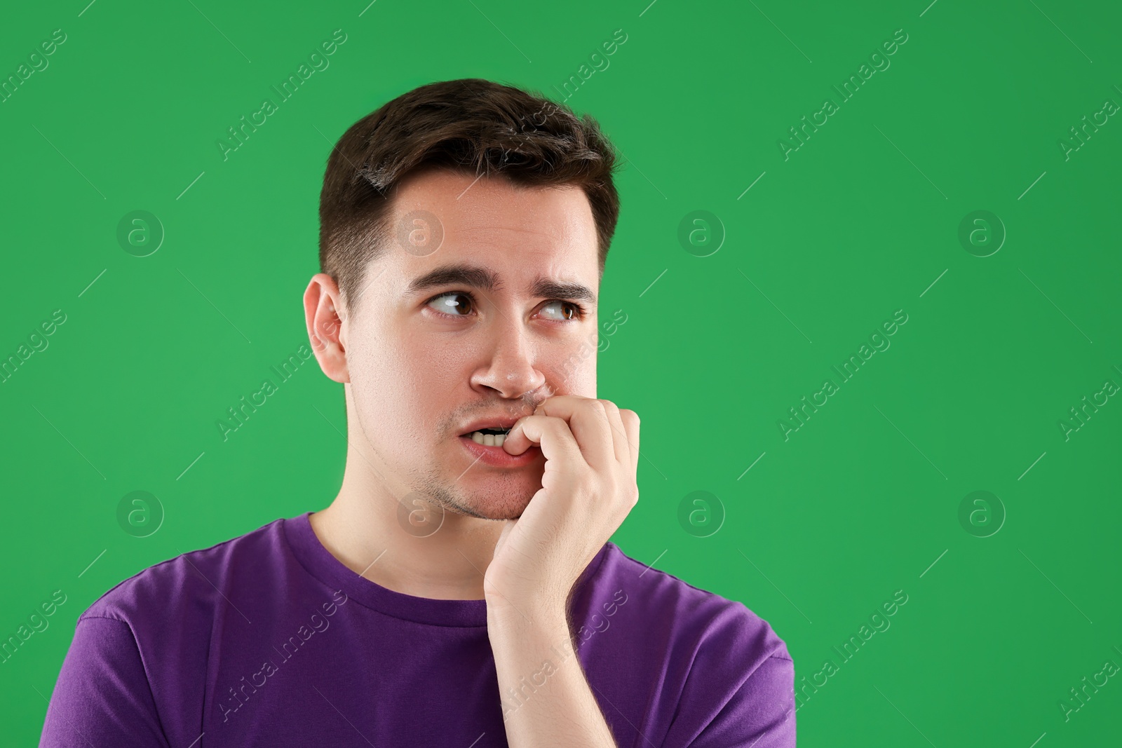 Photo of Portrait of scared young man on green background, space for text