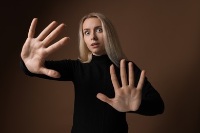 Portrait of scared woman on brown background