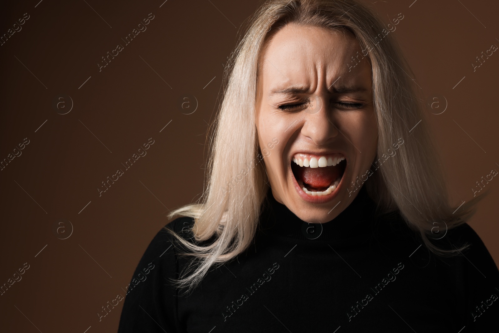 Photo of Portrait of scared woman on brown background