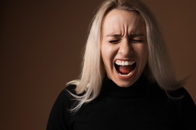 Portrait of scared woman on brown background