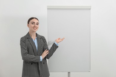 Happy woman near flip chart on white background. Mockup for design