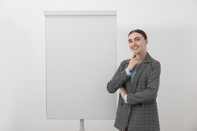 Happy woman near flip chart on white background. Mockup for design