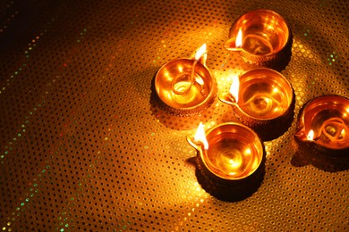 Photo of Diwali celebration. Diya lamps on color background. Space for text