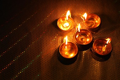 Photo of Diwali celebration. Diya lamps on color background. Space for text