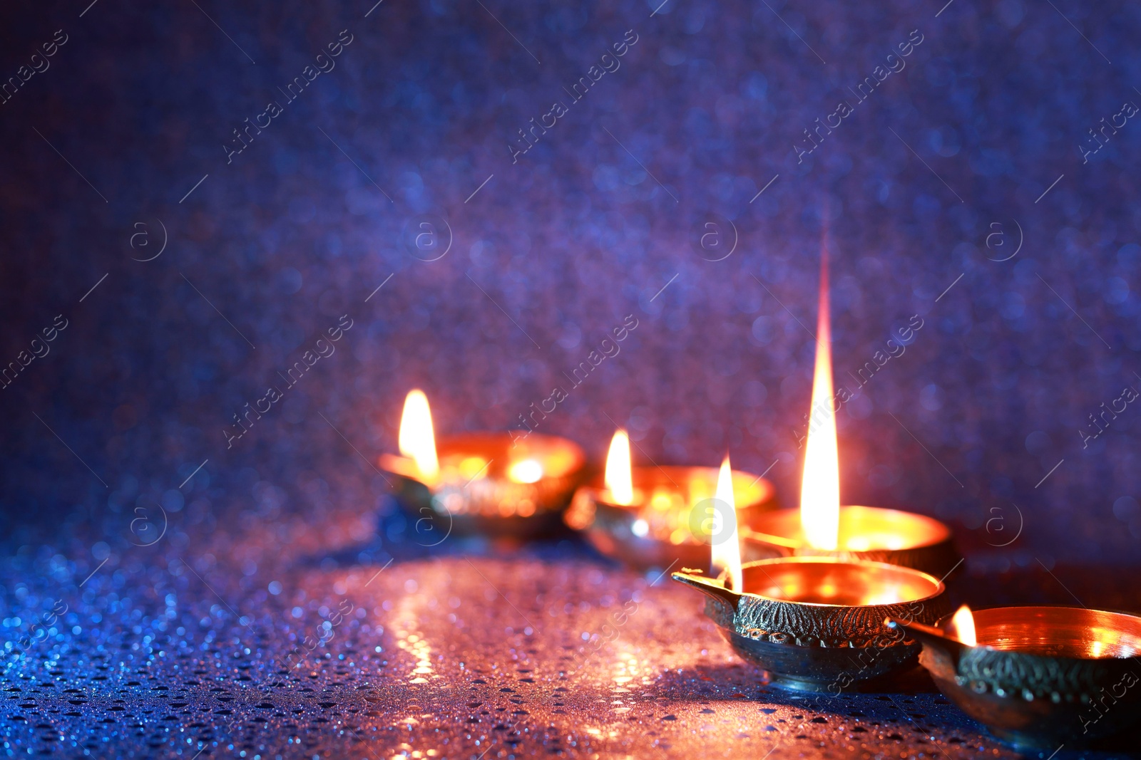 Photo of Diwali celebration. Diya lamps on color background. Space for text