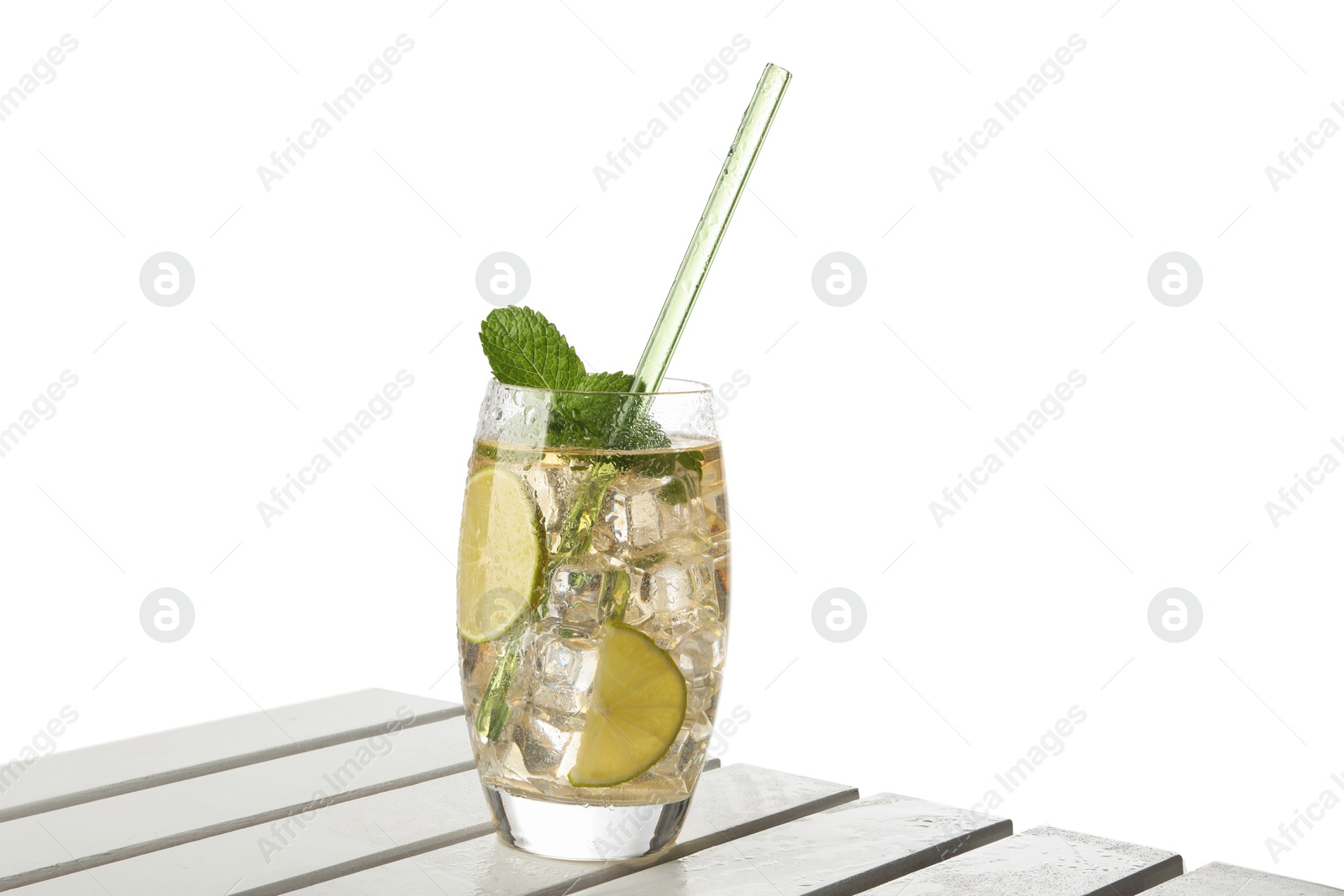 Photo of Glass of tasty refreshing drink and straw on wooden table against white background