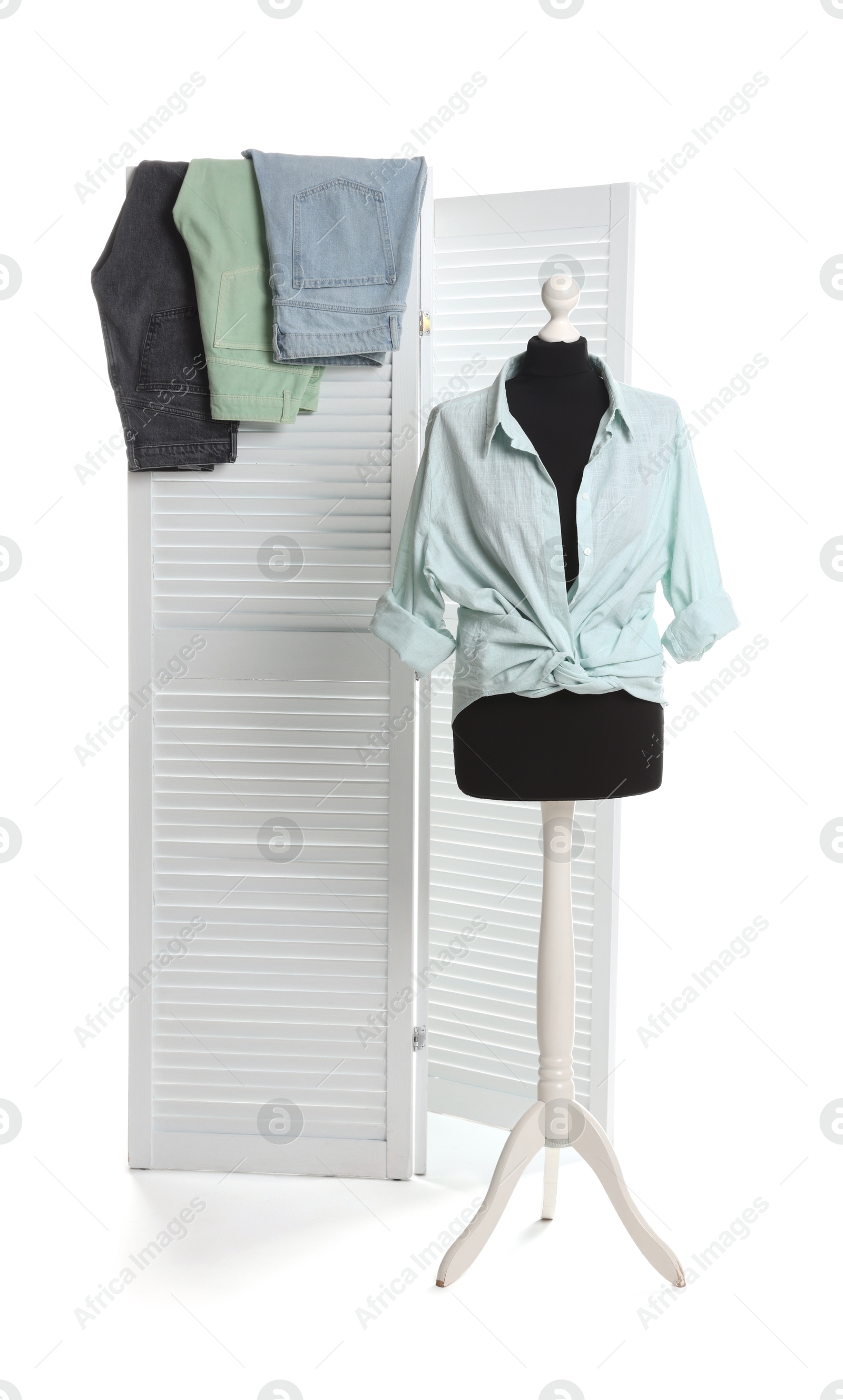 Photo of Female mannequin with stylish shirt and different jeans isolated on folding screen against white background