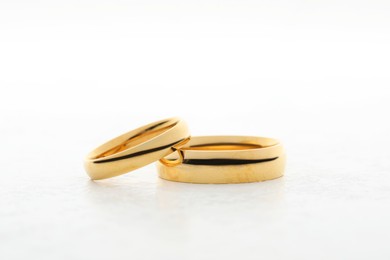 Photo of Beautiful golden wedding ring on white table