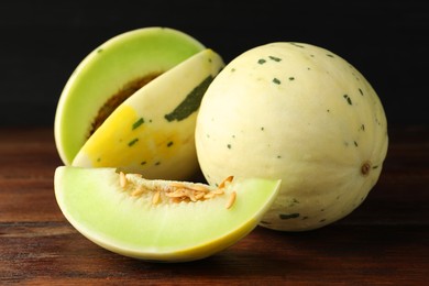 Photo of Fresh ripe honeydew melons on wooden table