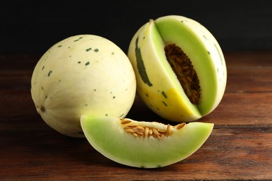 Photo of Fresh ripe honeydew melons on wooden table