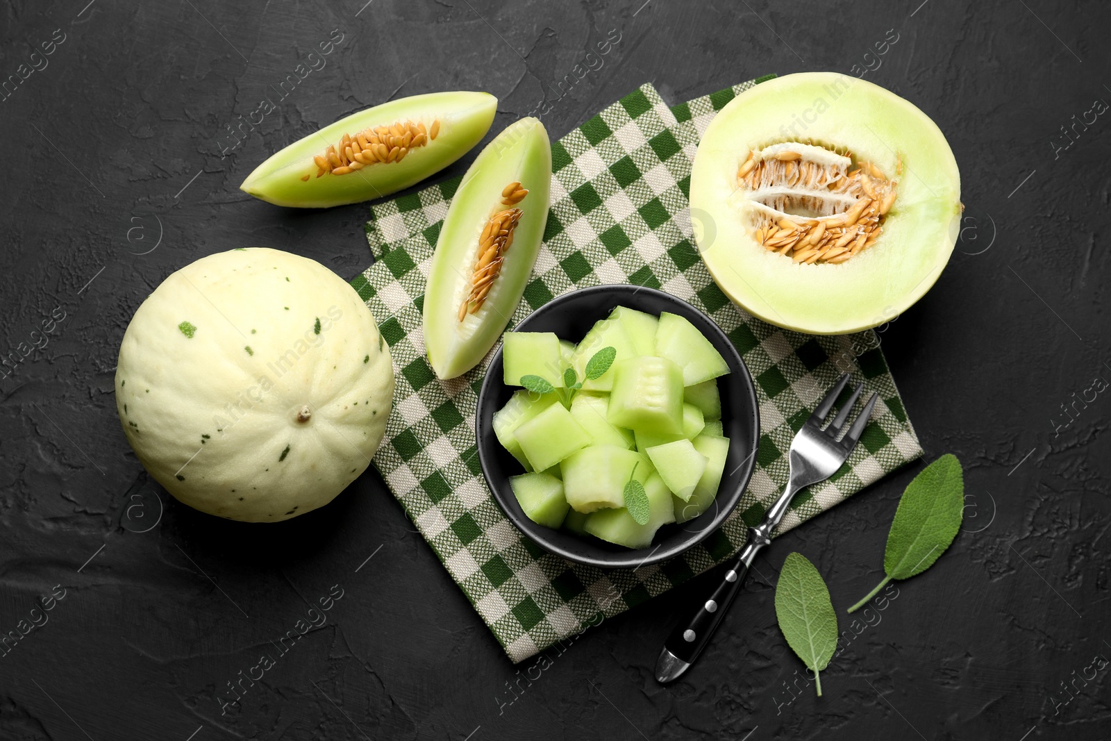 Photo of Slices of yummy melon on dark table, flat lay