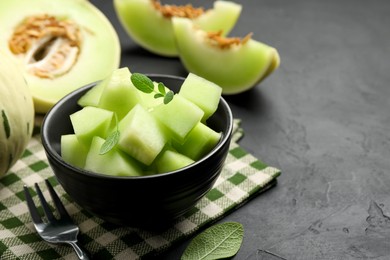 Photo of Slices of yummy melon on dark table, closeup. Space for text