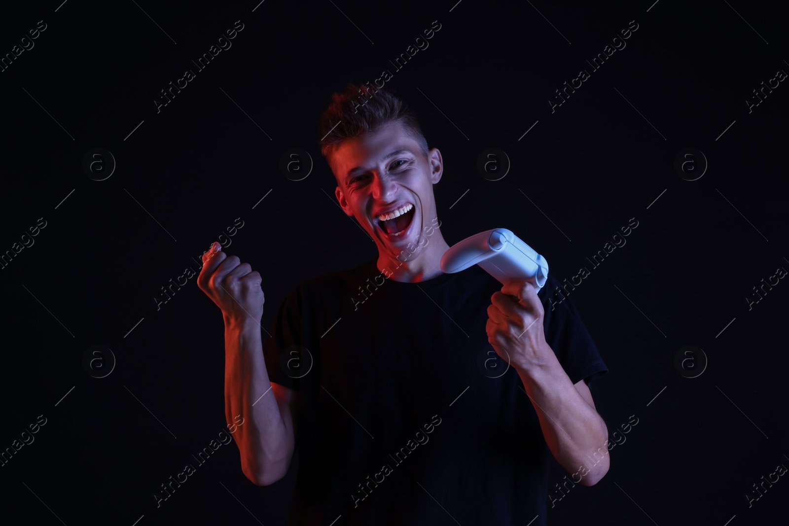 Photo of Happy young man with controller on black background