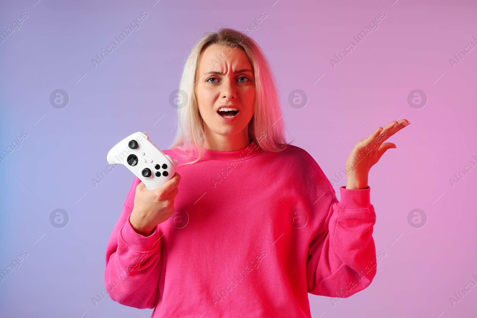 Photo of Unhappy woman with controller on color background