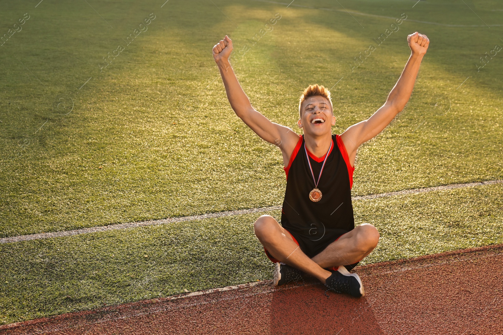 Photo of Happy winner with silver medal at stadium. Space for text