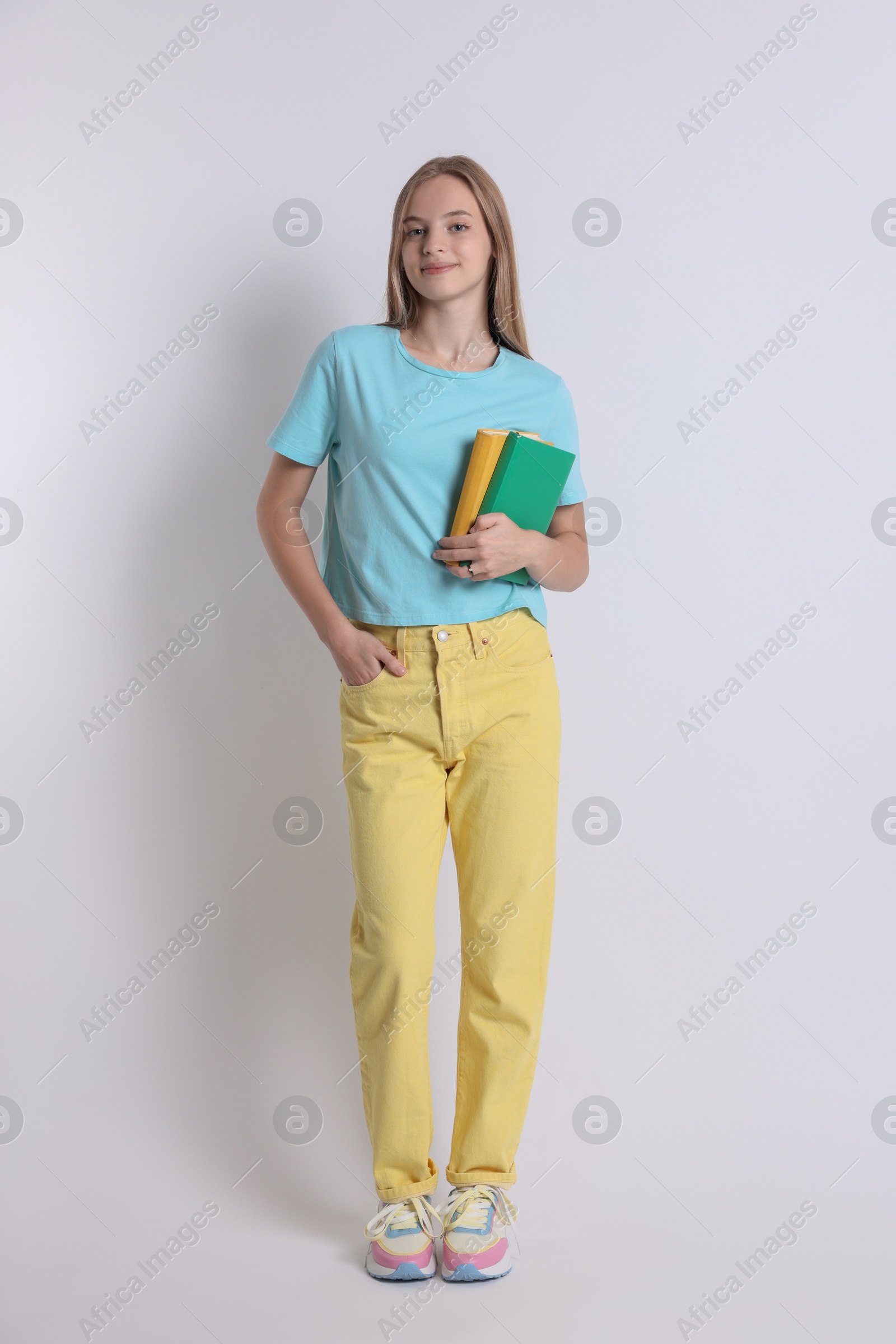 Photo of Teenage girl with books on white background