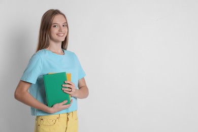 Photo of Teenage girl with books on white background, space for text