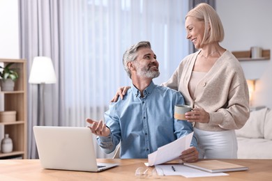 Photo of Happy middle aged couple working at home