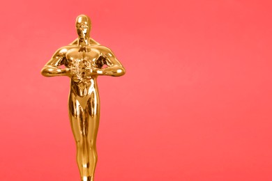 Golden trophy in shape of human figure on red background, space for text