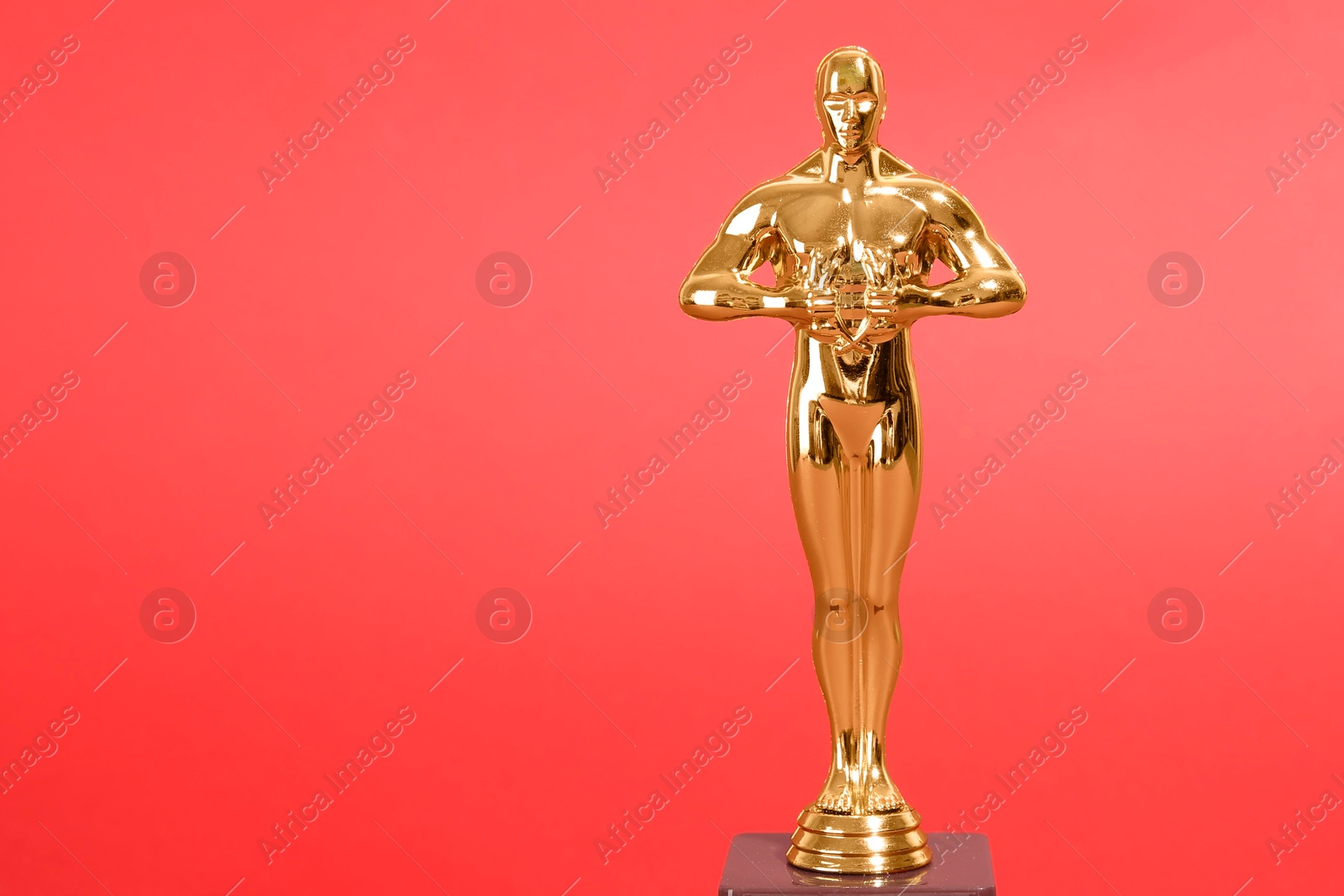 Photo of Golden trophy in shape of human figure on red background, space for text