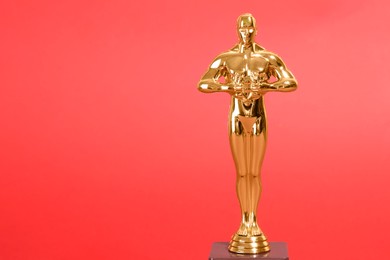 Photo of Golden trophy in shape of human figure on red background, space for text