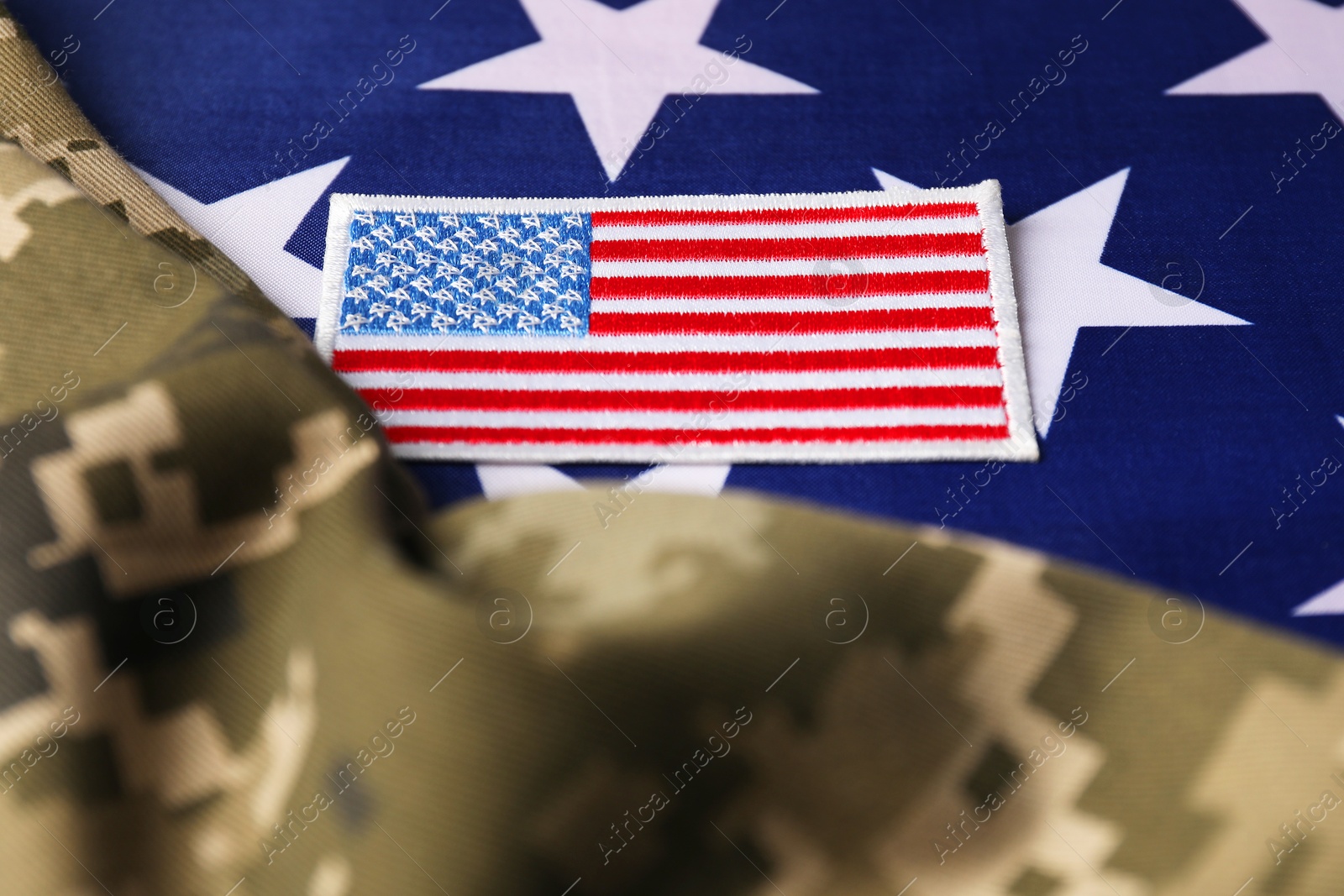 Photo of Veterans day. USA army patch and military uniform on American flag, closeup