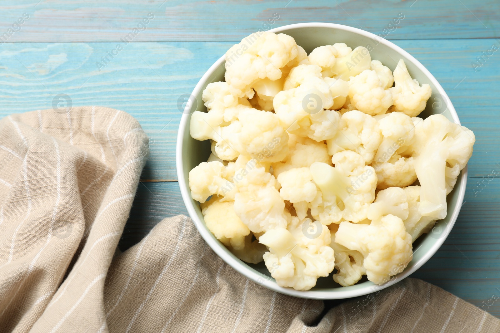 Photo of Tasty cooked cauliflower on light blue wooden table, top view