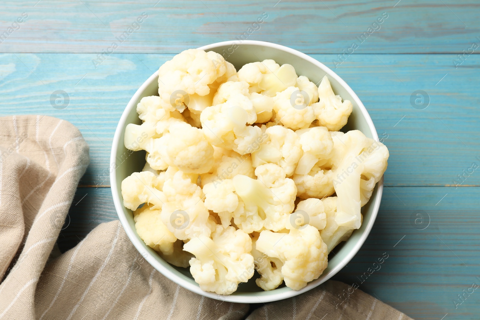 Photo of Tasty cooked cauliflower on light blue wooden table, top view