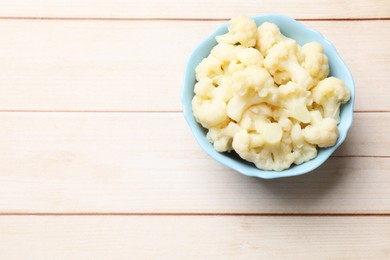 Photo of Tasty cooked cauliflower on white wooden table, top view. Space for text