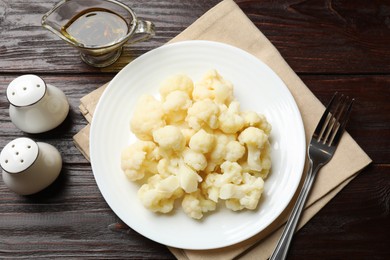 Photo of Tasty cooked cauliflower served on wooden table, flat lay