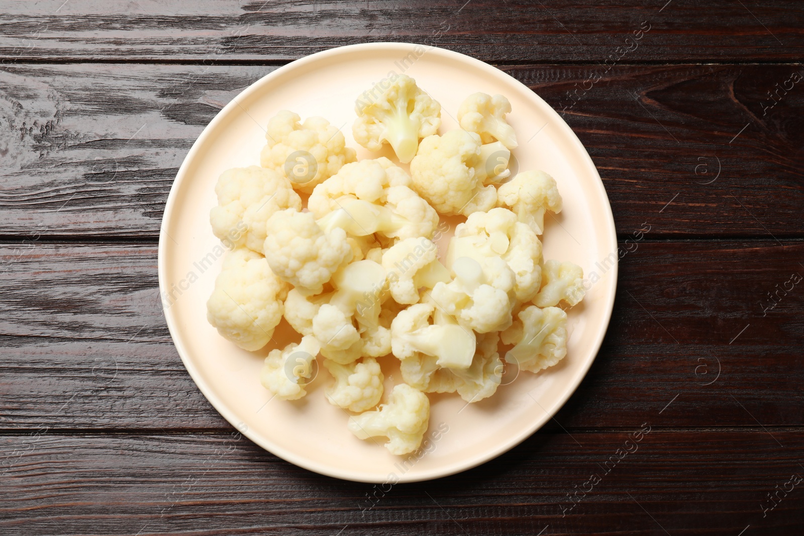 Photo of Tasty cooked cauliflower on wooden table, top view