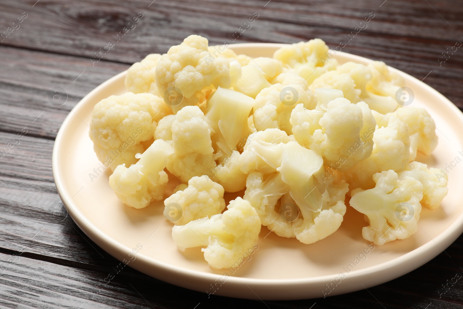 Photo of Tasty cooked cauliflower on wooden table, closeup