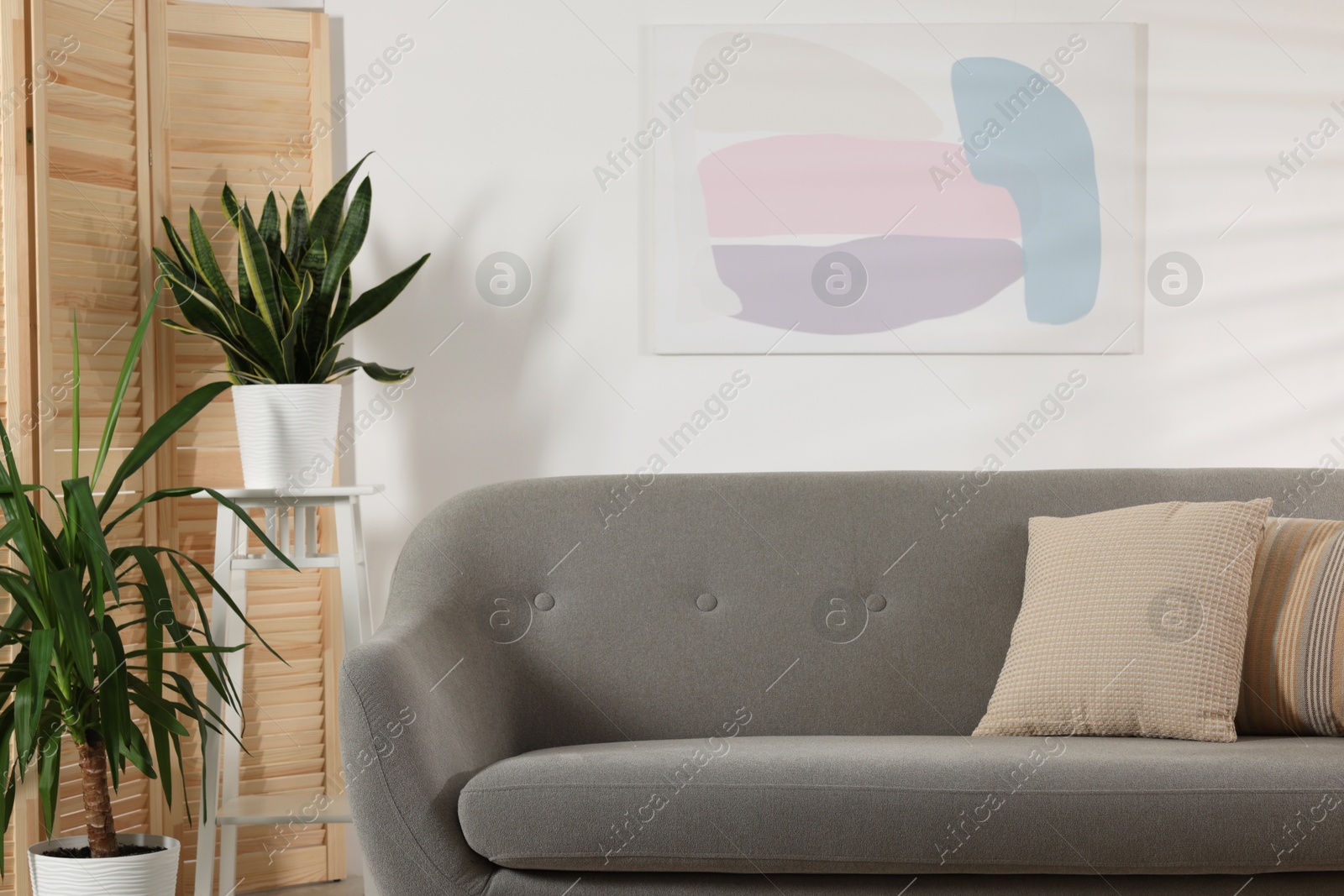 Photo of Living room interior with folding screen and soft sofa