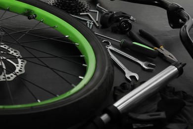 Parts of bicycle and tools on black background, closeup