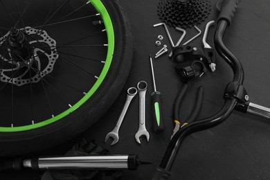 Parts of bicycle and tools on black background