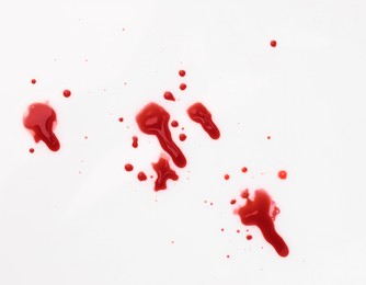 Photo of Stains of blood on white background, top view