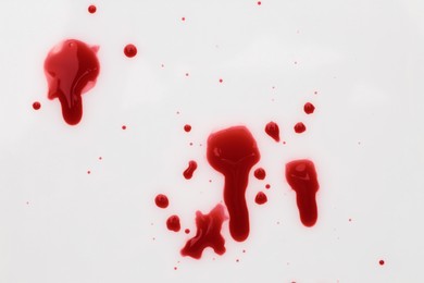 Photo of Stains of blood on white background, top view