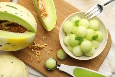 Photo of Melon balls in bowl and fresh fruit on table, top view