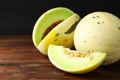 Photo of Fresh ripe honeydew melons on wooden table, space for text