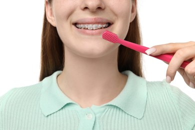 Photo of Girl with braces holding toothbrush on white background, closeup