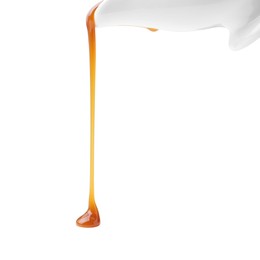 Photo of Tasty caramel sauce dripping on white background, closeup