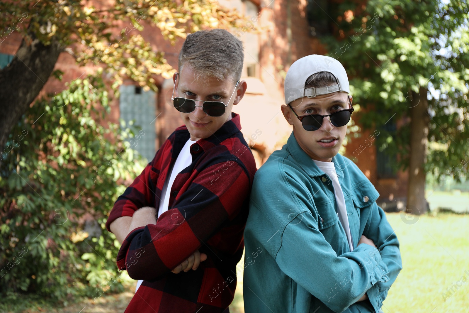 Photo of Family portrait of handsome brothers with crossed arms outdoors