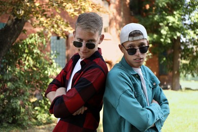 Photo of Family portrait of handsome brothers with crossed arms outdoors