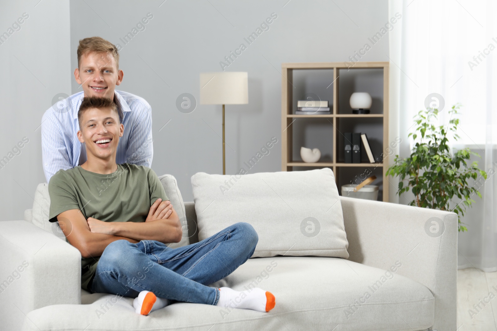 Photo of Happy brothers spending time together at home. Space for text