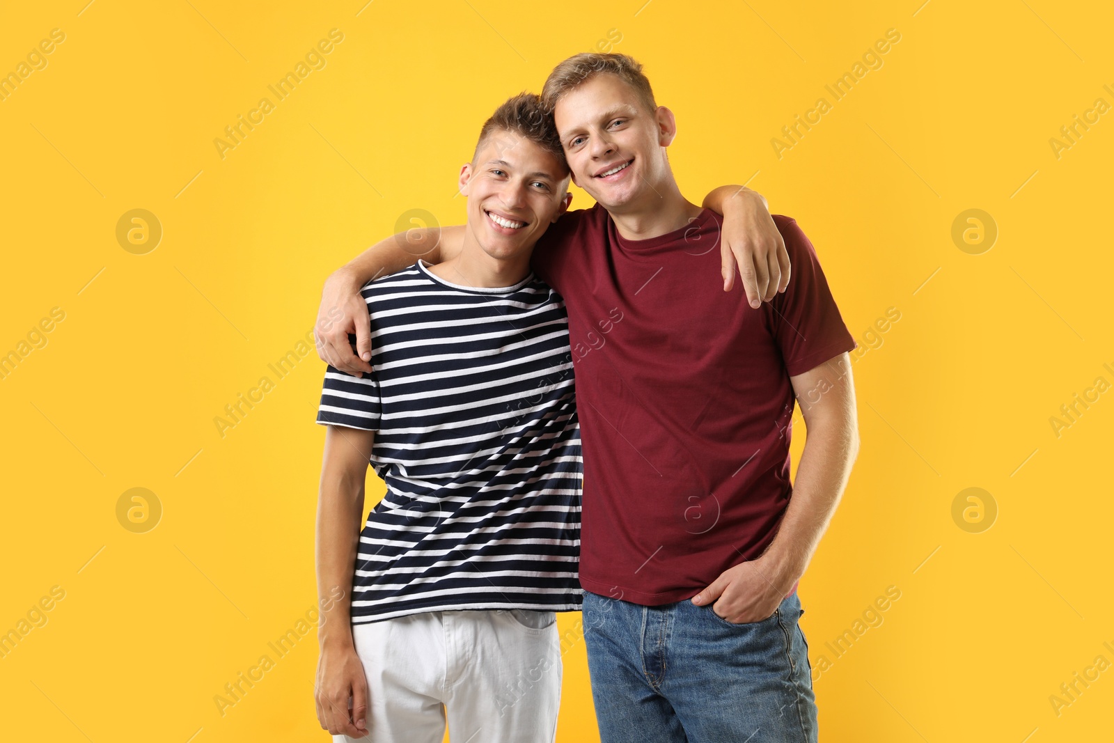 Photo of Portrait of happy brothers on orange background