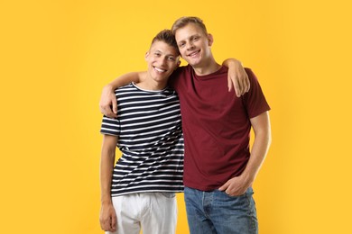 Photo of Portrait of happy brothers on orange background