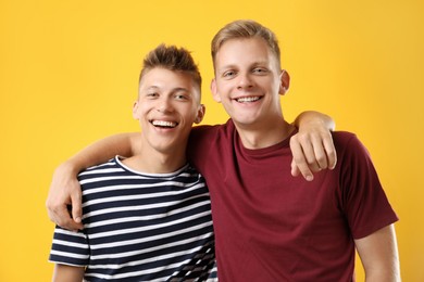 Photo of Portrait of happy brothers on orange background