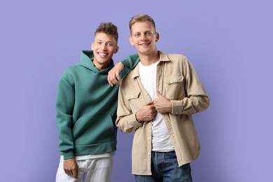 Photo of Portrait of happy brothers on violet background