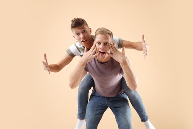 Photo of Portrait of funny brothers on beige background